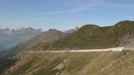 Cars-drive-on-scenic-road-with-mountains-in-background