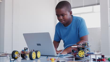 Male Student Building And Programing Robot Vehicle In After School Computer Coding Class