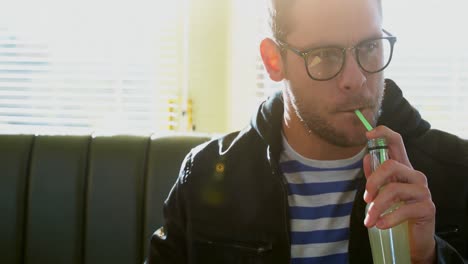 hombre bebiendo jugo mientras come papas fritas 4k