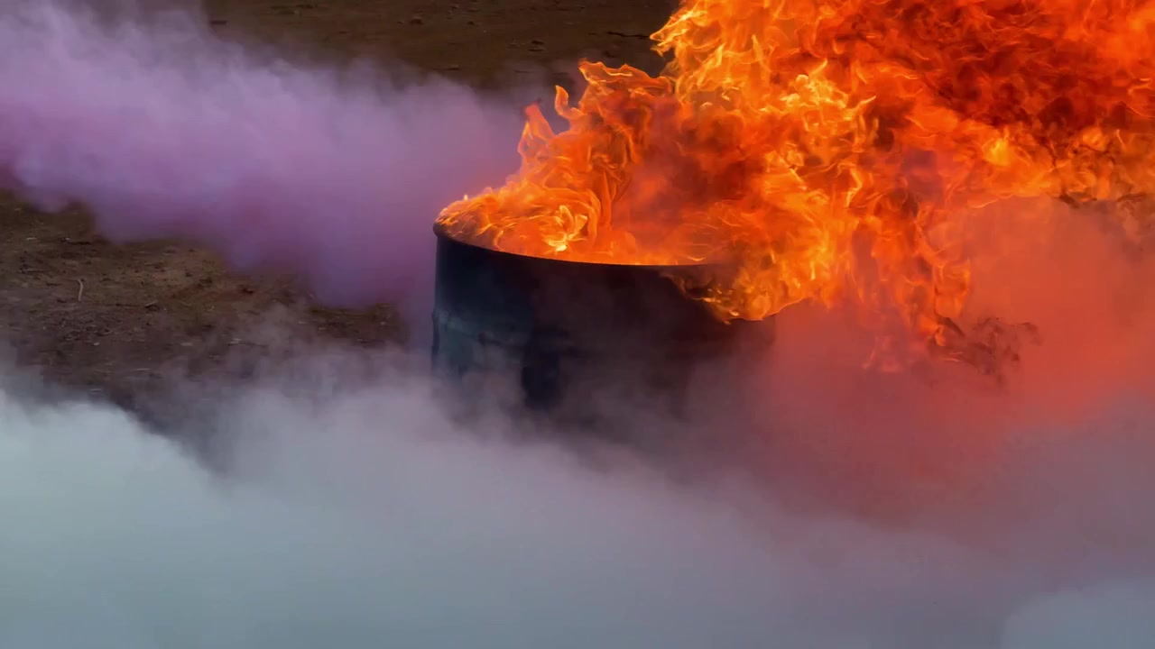 fire extinguisher putting out flames with powder. Safety, emergency response, and firefighting training concept footage.