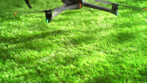 drone landing on a lush green grass on a sunny day in slow motion