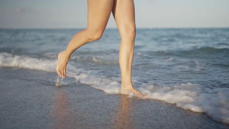 person running barefoot in the ocean at the beach