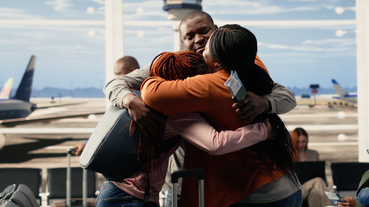 Bittersweet goodbye between parents and teen daughter in busy airport terminal