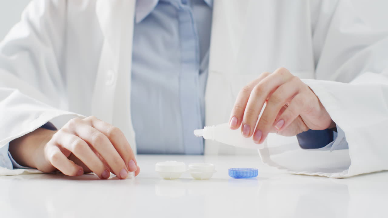 백인 의사가 콘택트 렌즈 케이스에 렌즈 용액을 넣는 중간 부분의 비디오