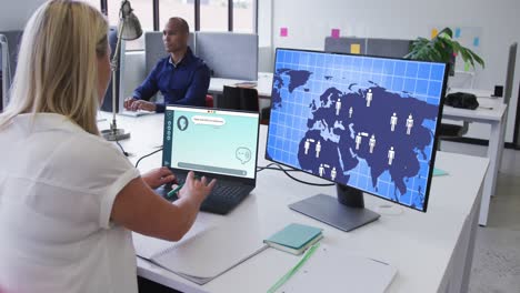 Caucasian-businesswoman-using-computers-with-data-processing-on-screen-in-office