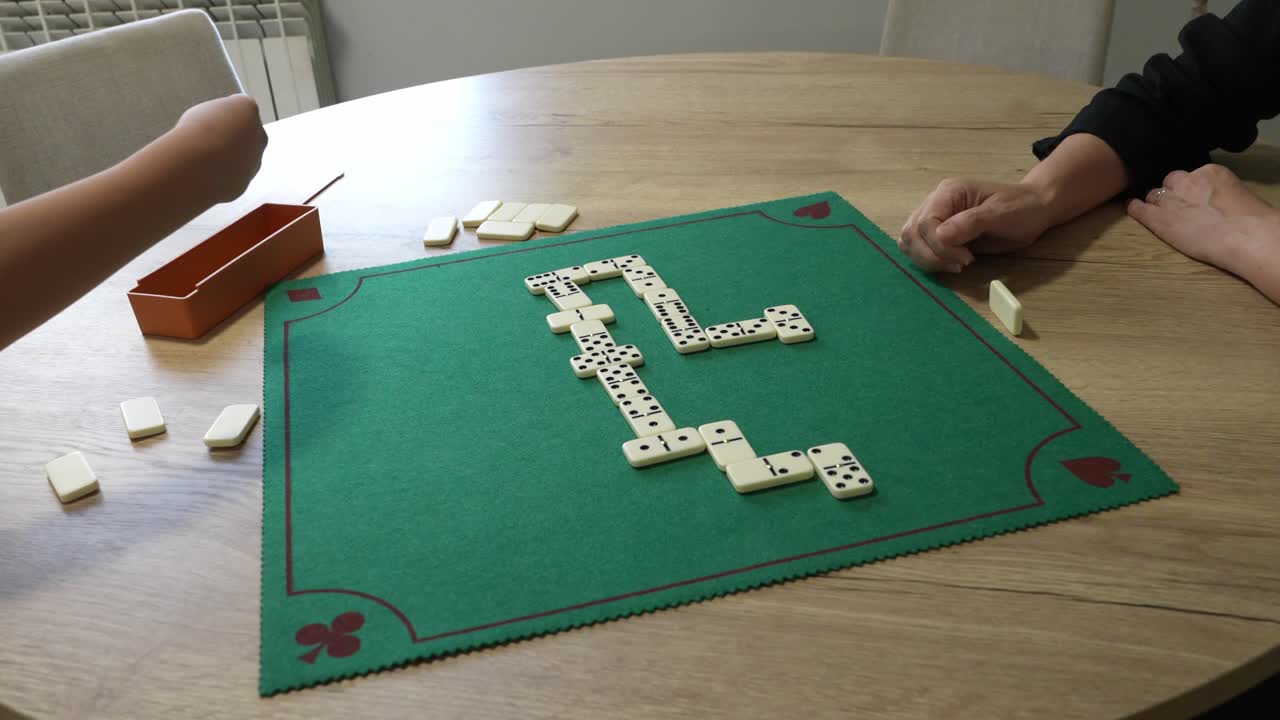 Partita a domino su un tavolo rotondo con persone che giocano
