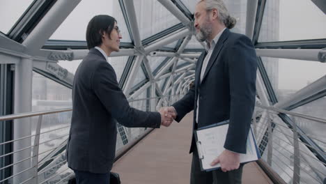 businessmen handshake on a modern bridge