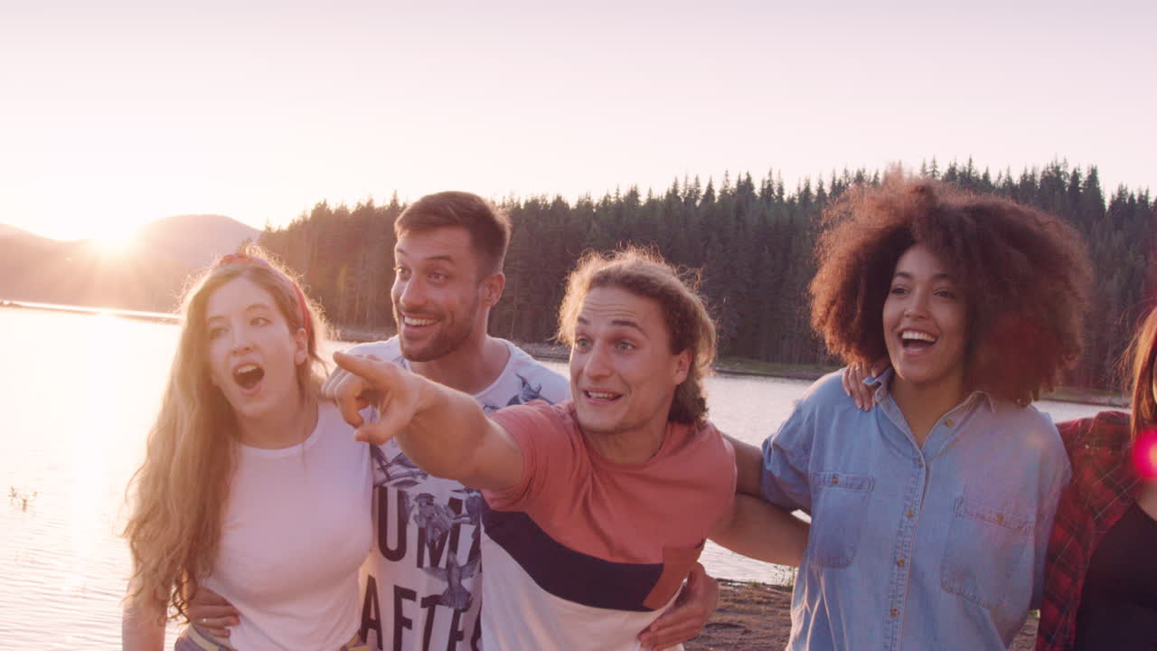 Amici che ridono e indicano al tramonto