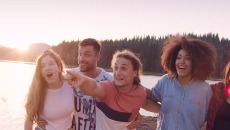 amigos riendo y señalando el atardecer