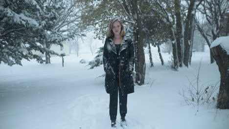 Woman-walking-outside-in-slow-motion-winter-snow-as-snowflakes-fall-in-cinematic-slow-motion