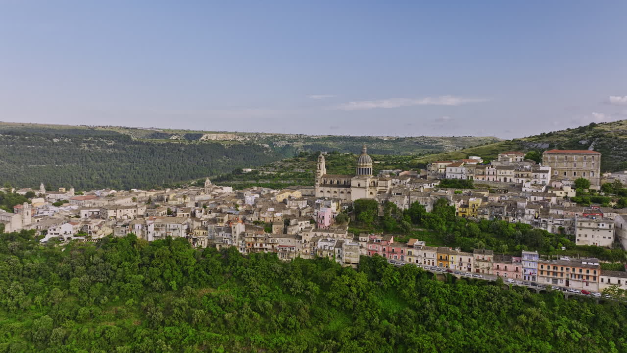 Ragusa, Italia, sorvolo aereo inverso v1 della valle che riprende il pittoresco paesaggio di Ragusa Ibla con un'incantevole chiesa e la città storica annidata sulla collina - Ripreso con Mavic 3 Cine - Giugno 2023