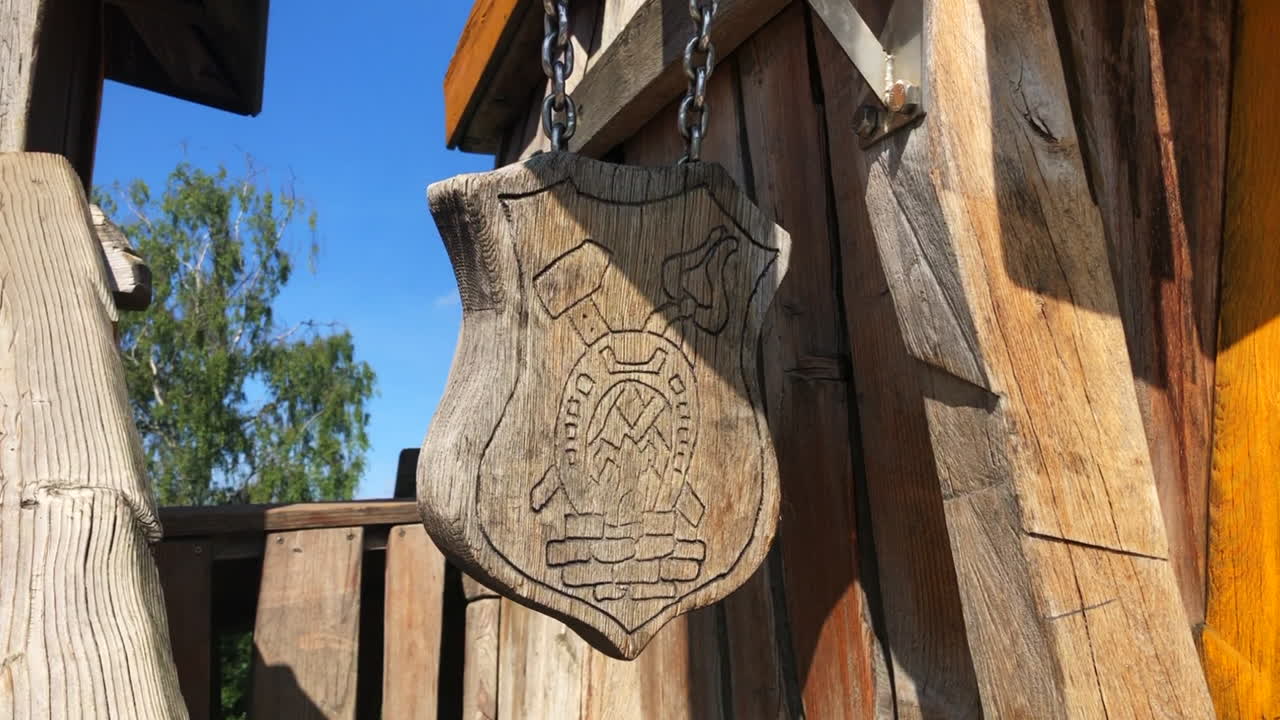 A decorative playground themed blacksmith scutcheon swaying in the wind