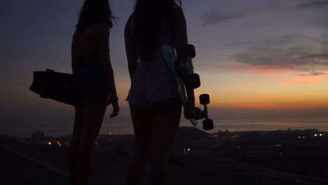 after riding their skateboards on the mountain, friends take in the stunning sunset horizon