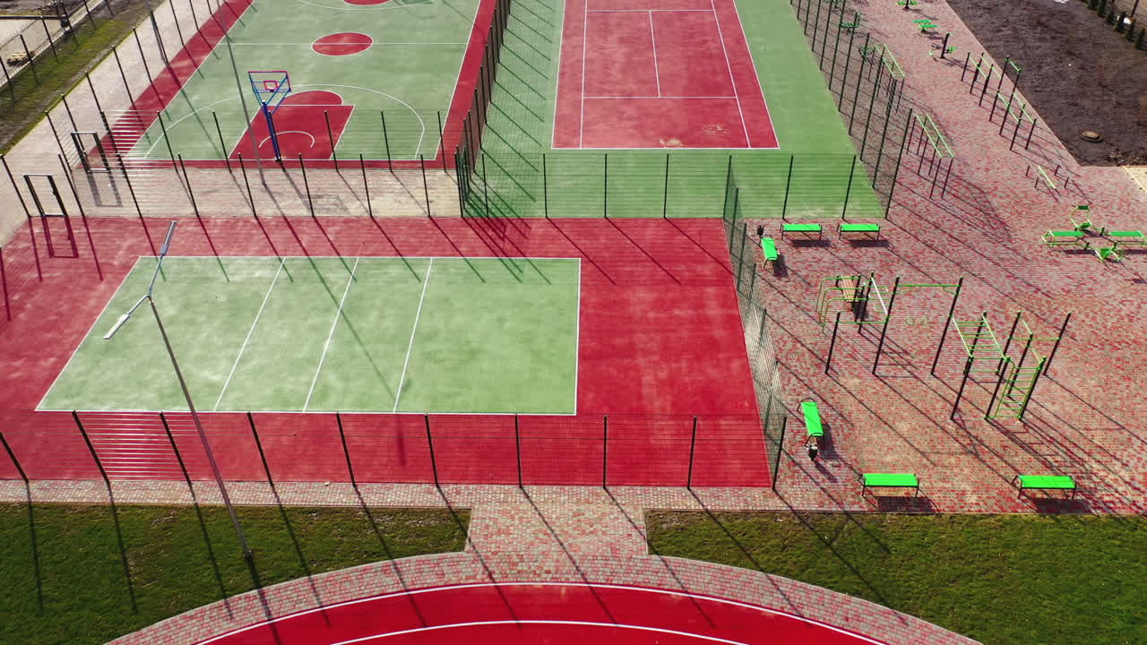 Mini stadiums for doing sport outdoors. Modern sport grounds in the city. Red and green sport fields with artificial grass. View from above.