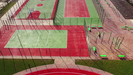 mini stadiums for doing sport outdoors. modern sport grounds in the city. red and green sport fields with artificial grass. view from above.