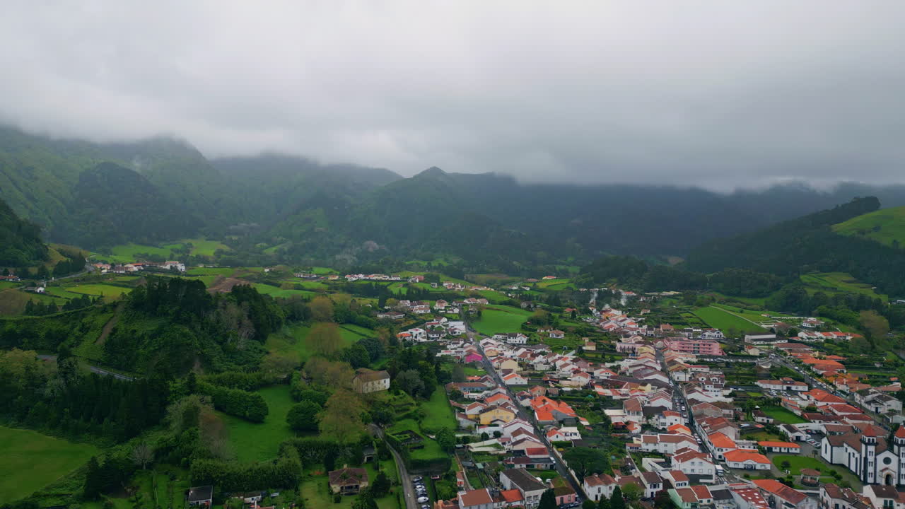 paisagem aérea complexo de edifícios da aldeia. campo chuvoso nebuloso encostas rurais