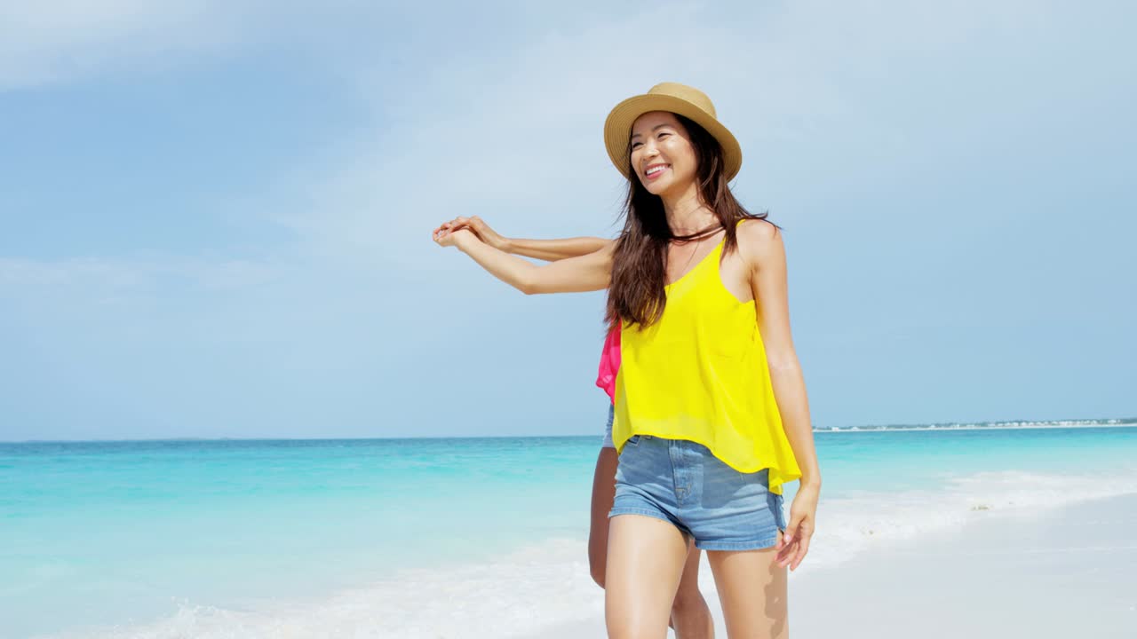 해변에서 모자를 입은 웃는 다민족 여성