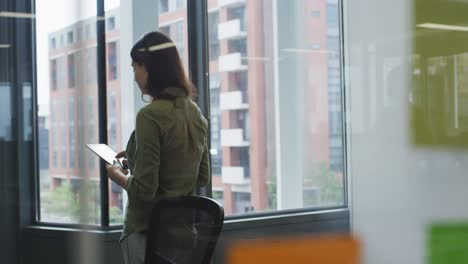 mujer de negocios caucásica en la sala de reuniones usando una tableta