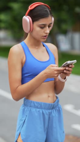 woman exercising outdoors and using phone