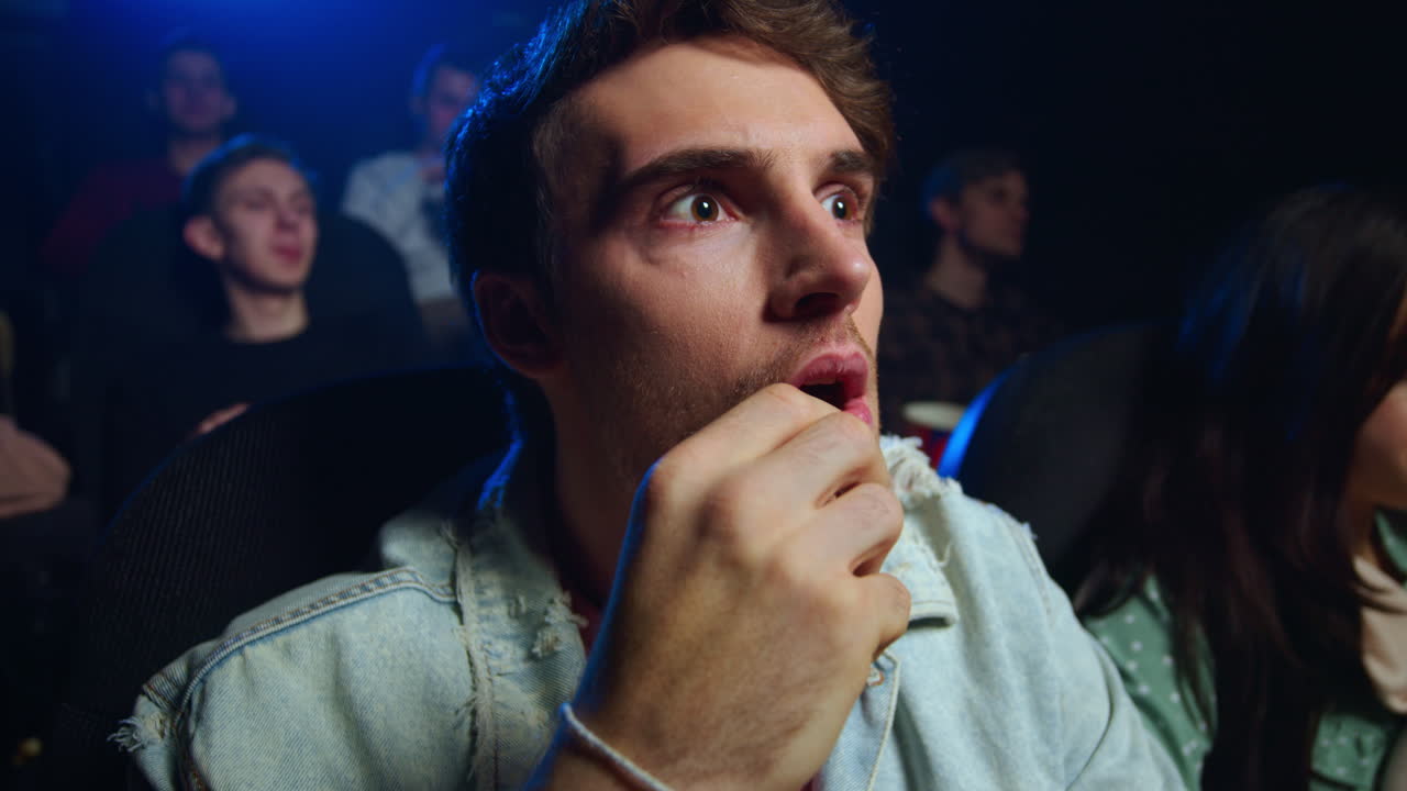 실내에서 영화를 보는 표현적인 남자