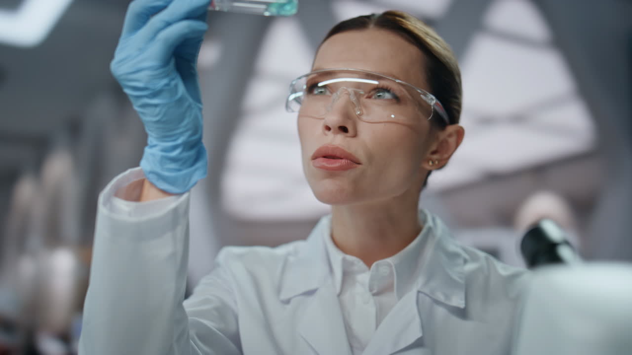 лабораторный работник заполняет пробирку экспериментальным лекарством, делая исследования вблизи.