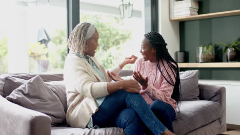 Feliz-Madre-E-Hija-Afroamericana-Sentadas-En-El-Sofá-Y-Abrazándose,-Cámara-Lenta