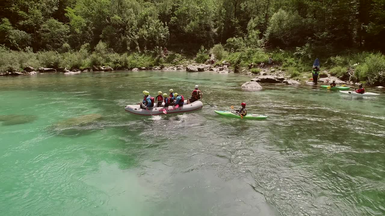 Letecký pohled na skupinu sedící v lodi a připravující se na rafting na řece Soča.