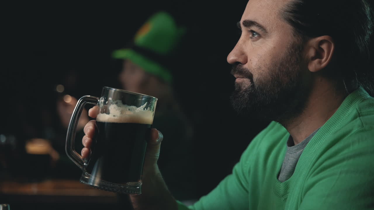 Portrait of a man drinking a beer mug. Celebrating Saint Patrick's Day in a pub.