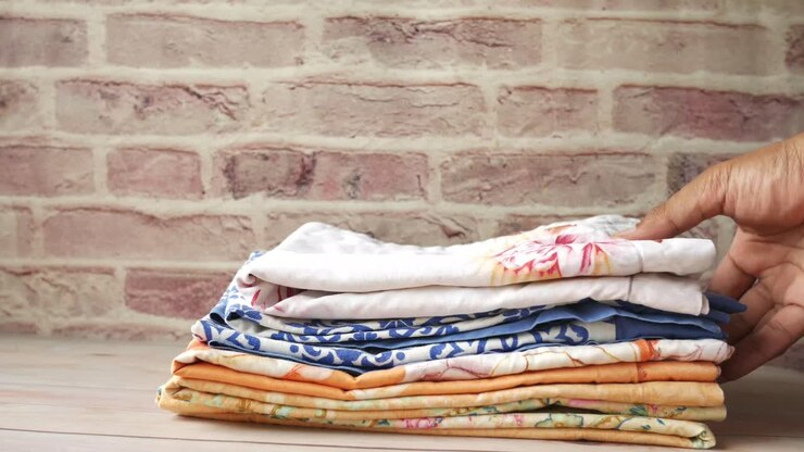 Folded Clothes Stacked on Wooden Table