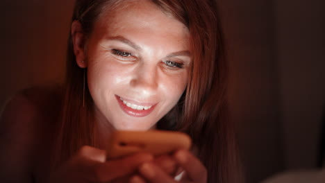 mujer usando teléfono inteligente por la noche