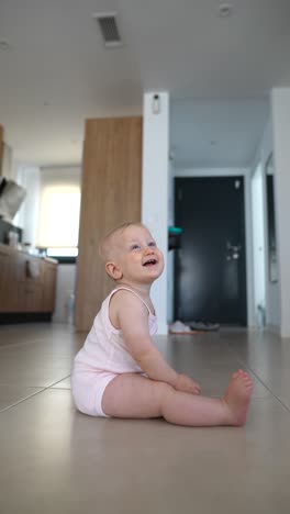 baby girl sitting on the floor in a modern kitchen