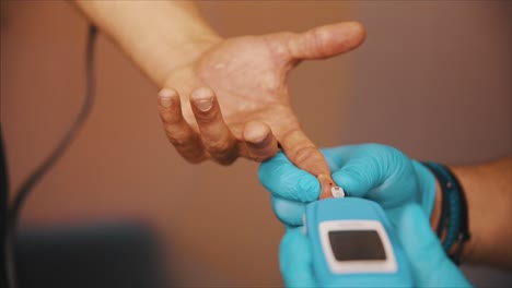 doctor measures blood glucose level with a glucometer