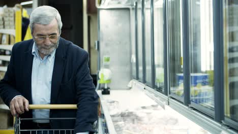 mature man buying goods in store