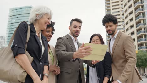 diverse business team collaborating outdoors with a tablet