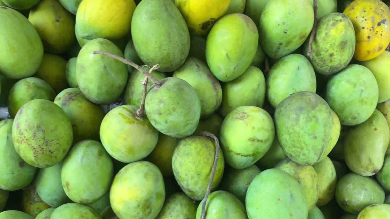 montón de mangos verdes en el mercado