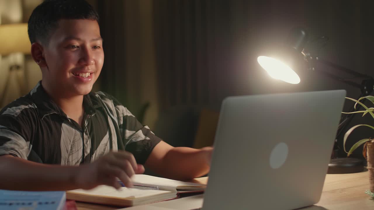 Young Asia Boy Student Celebrating With Laptop Computer At Home, Teenage Boy Learning Online From Laptop At Night