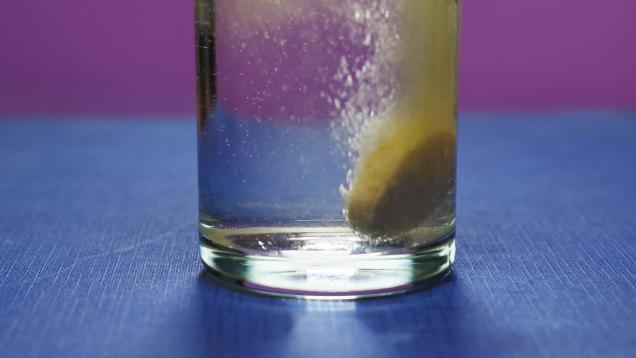 Effervescent tablet vitamin C nutritional supplements in glass with orange carbonated water.Aspirin antipyretic drugs.Vitamins C pills against flu, medicines. Healthy concept immune system High quality 4k footage