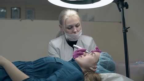 woman in white coat and mask colours lady eyebrow in black