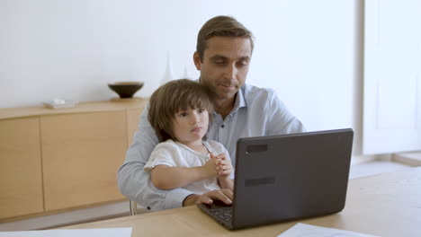 dad holding little son on lap