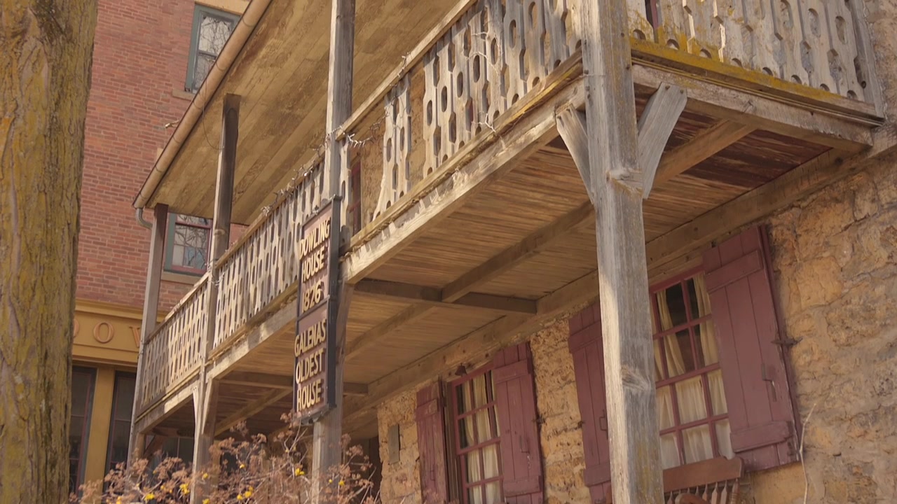 Storica Dowling House in pietra con balcone in legno e sedie rustiche a Galena.