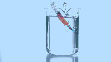 animación de formas rojas que giran sobre una jeringa con reactivo en vidrio sobre fondo azul