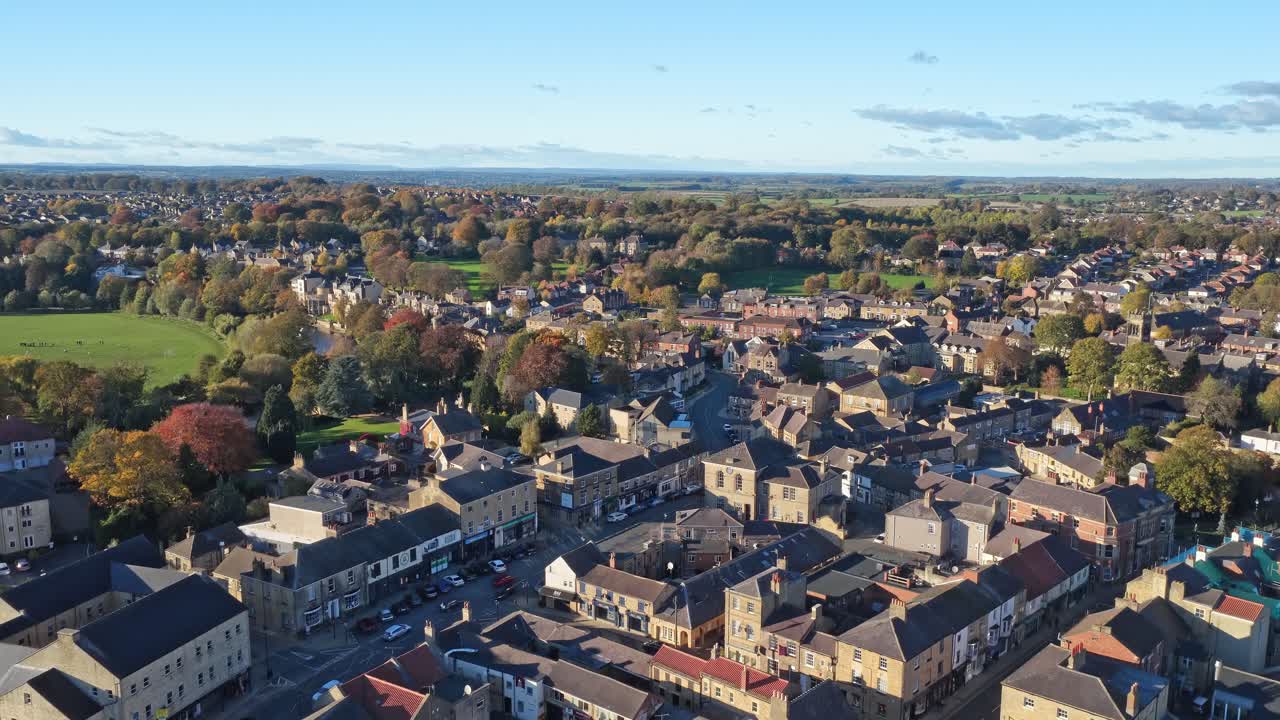Vista aerea da drone del centro della città di Wetherby che mostra tetti, negozi nel centro della città, layout urbano, parchi verdi e alberi sotto un cielo sereno. Atmosfera da città britannica ed edifici storici