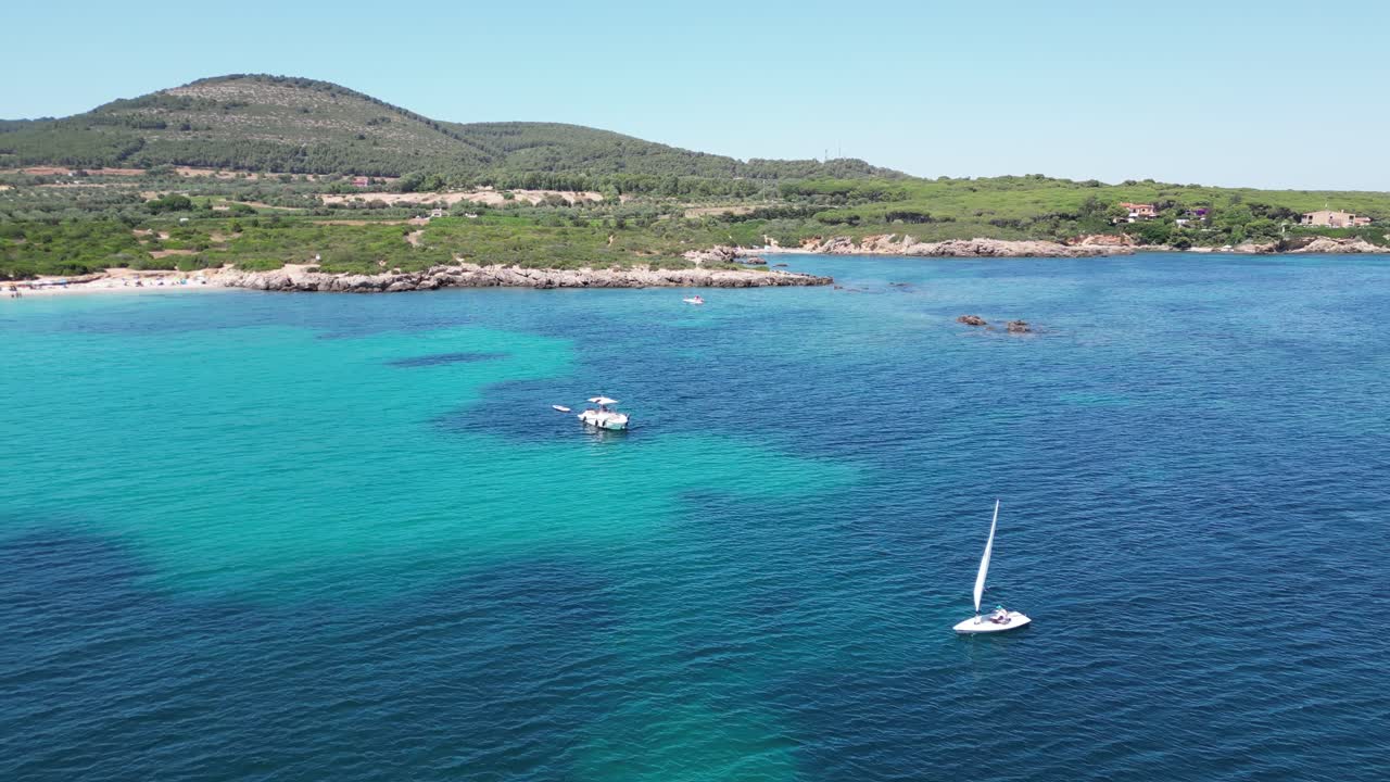 Velejador solitário navega ao longo da Praia de Cala Spinosa na Sardenha, Itália - Aéreo 4K