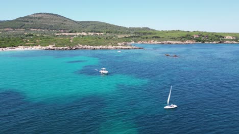 Solo-Segler-Segelt-Am-Strand-Von-Cala-Spinosa-In-Sardinien,-Italien---4k-Antenne