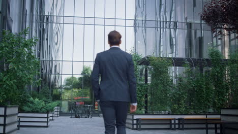 confident businessman walking business center garden alone. success concept.