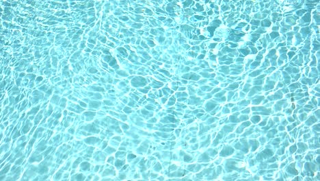 pure blue water in the swimming pool with light reflections in slow motion. aerial footage.