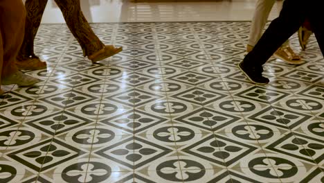 feet moving across patterned tiles in bangkok