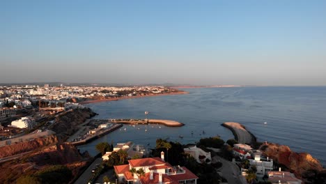 Luftaufnahme-Der-Stadt-Mit-Kleinem-Hafen,-Die-Ein-Großes-Luxushaus-Bei-Sonnenuntergang-In-Albufeira,-Portugal,-Enthüllt