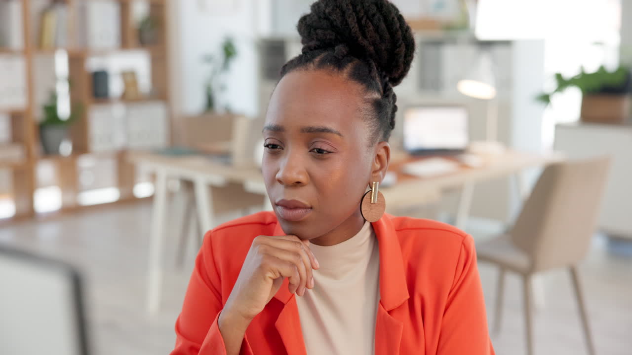 Thoughtful Young Black Businesswoman Listening in a Modern Office
