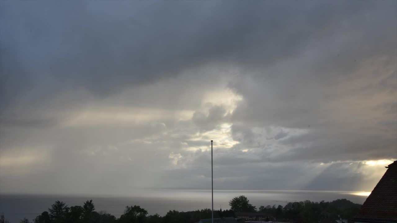 저속 촬영: 구름이 움직이고 일부 태양 빛이 구름을 통과하게 합니다.